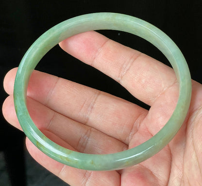 Close-up of fine crystalline texture and vivid imperial green hues on icy apple green jadeite bangle