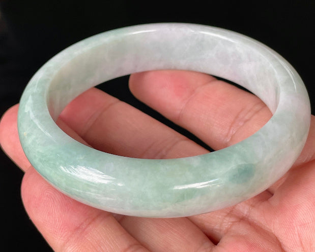 Close-up of fine crystalline texture and moss in the snow effect on icy milky white and green jadeite bangle