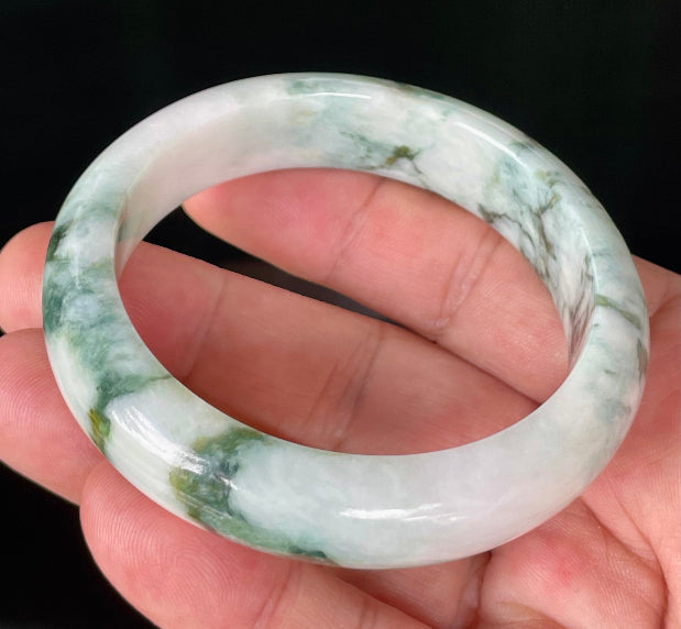 Close-up of fine crystalline texture and moss in the snow effect on icy milky white and green jadeite bangle