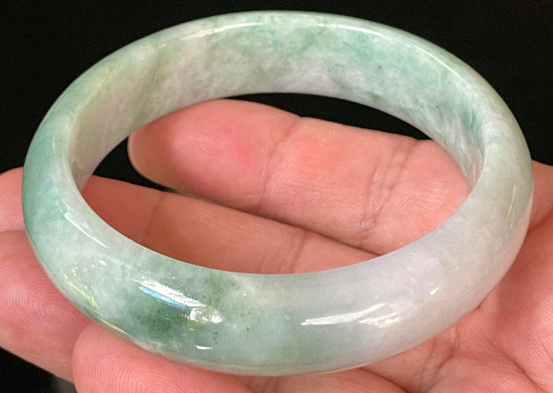 Close-up of fine crystalline texture and radiant imperial green hues on icy greyish white jadeite bangle