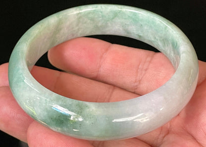Close-up of fine crystalline texture and radiant imperial green hues on icy greyish white jadeite bangle