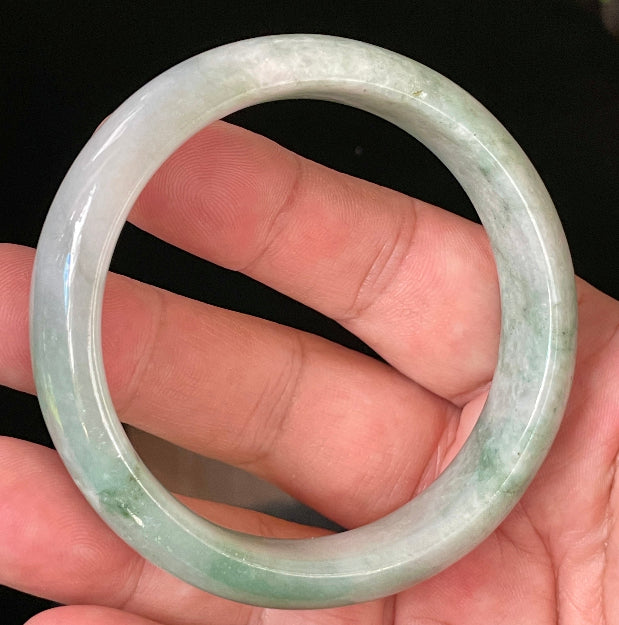 Close-up of fine crystalline texture and radiant imperial green hues on icy greyish white jadeite bangle
