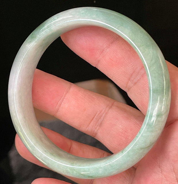 Close-up of fine crystalline texture and radiant imperial green hues on icy greyish white jadeite bangle