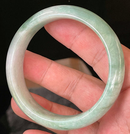 Close-up of fine crystalline texture and radiant imperial green hues on icy greyish white jadeite bangle