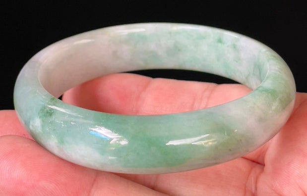 Close-up of fine crystalline texture and radiant imperial green hues on icy greyish white jadeite bangle