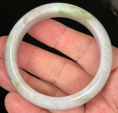 Close-up of fine crystalline texture and tranquil moss green hues on icy imperial green and white jadeite bangle