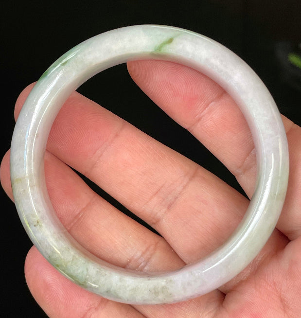 Close-up of fine crystalline texture and tranquil moss green hues on icy imperial green and white jadeite bangle