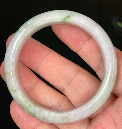 Close-up of fine crystalline texture and tranquil moss green hues on icy imperial green and white jadeite bangle
