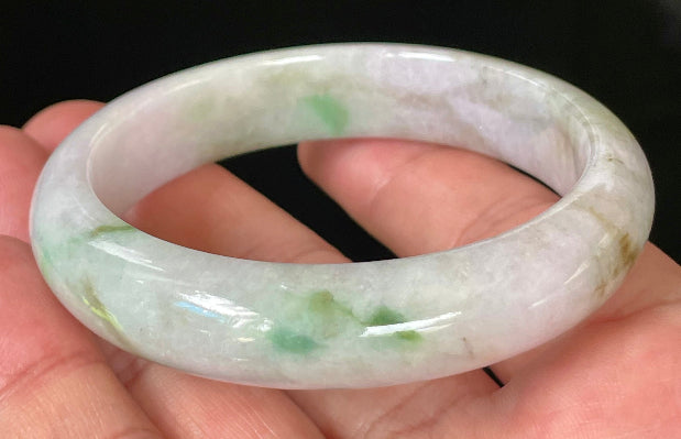 Close-up of fine crystalline texture and tranquil moss green hues on icy imperial green and white jadeite bangle