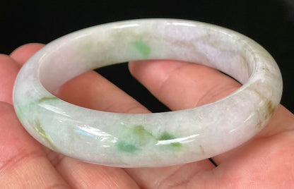 Close-up of fine crystalline texture and tranquil moss green hues on icy imperial green and white jadeite bangle