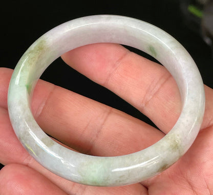 Close-up of fine crystalline texture and tranquil moss green hues on icy imperial green and white jadeite bangle