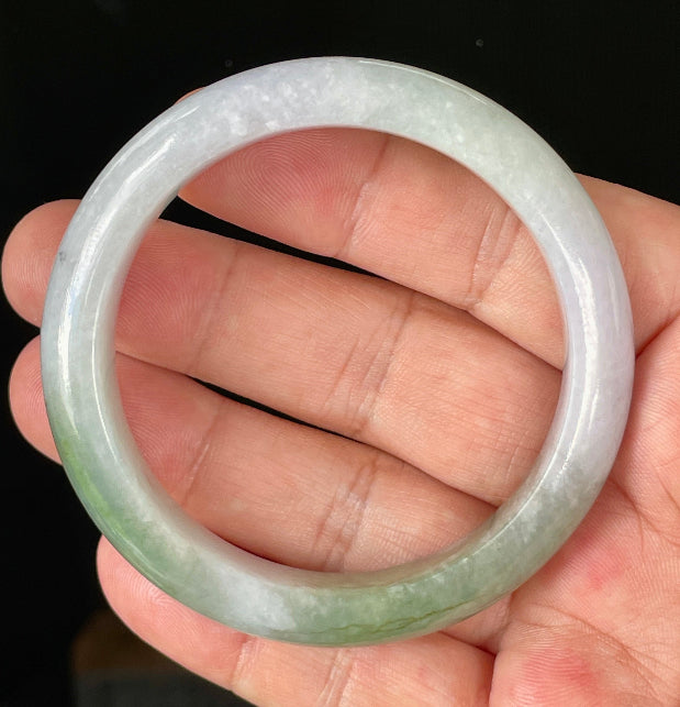 Close-up of fine crystalline texture and moss in the snow effect on icy light lavender and apple green jadeite bangle
