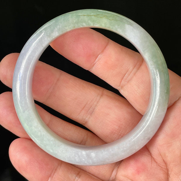 Close-up of fine crystalline texture and moss in the snow effect on icy light lavender and apple green jadeite bangle