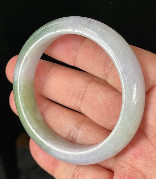 Close-up of fine crystalline texture and moss in the snow effect on icy light lavender and apple green jadeite bangle