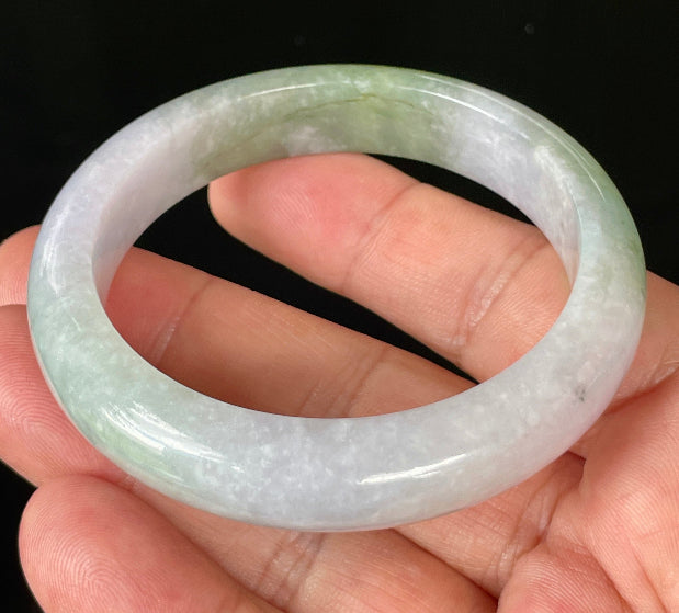 Close-up of fine crystalline texture and moss in the snow effect on icy light lavender and apple green jadeite bangle