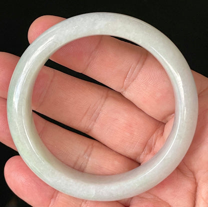 Close-up of fine crystalline texture and delicate light apple green hues on icy milky white jadeite bangle