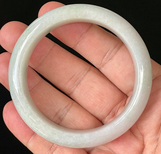 Close-up of fine crystalline texture and delicate light apple green hues on icy milky white jadeite bangle