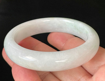 Close-up of fine crystalline texture and delicate apple green hues on icy milky white jadeite bangle