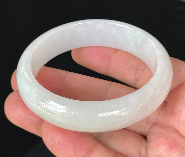 Close-up of fine crystalline texture and gentle honey tones on icy milky white jadeite bangle