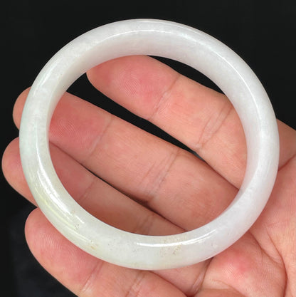 Close-up of fine crystalline texture and gentle honey tones on icy milky white jadeite bangle