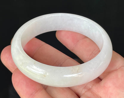 Close-up of fine crystalline texture and gentle honey tones on icy milky white jadeite bangle