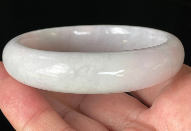 Close-up of fine crystalline texture and gentle light lavender hues on icy milky white jadeite bangle