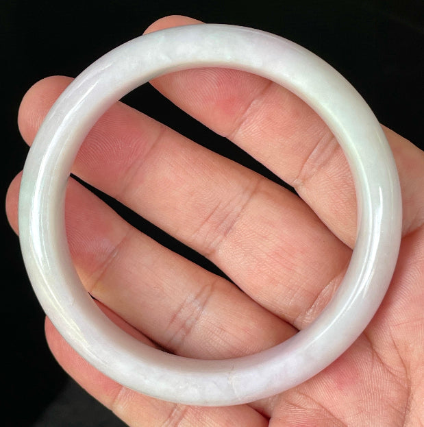 Close-up of fine crystalline texture and gentle light lavender hues on icy milky white jadeite bangle