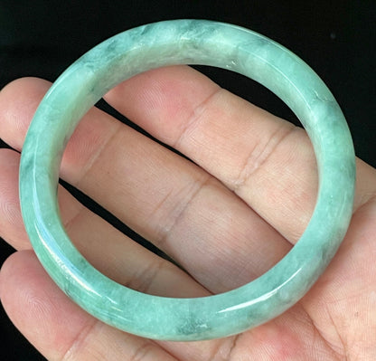 Close-up of fine crystalline texture and beautiful moss in the snow pattern on icy imperial green and white jadeite bangle
