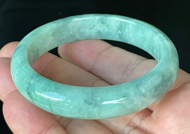 Close-up of fine crystalline texture and beautiful moss in the snow pattern on icy imperial green and white jadeite bangle