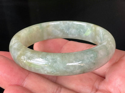 Close-up of fine crystalline texture and intricate natural jade veins on icy apple green jadeite bangle