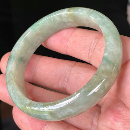 Close-up of fine crystalline texture and intricate natural jade veins on icy apple green jadeite bangle