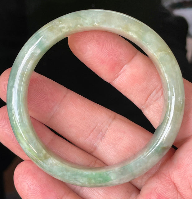 Close-up of fine crystalline texture and intricate natural jade veins on icy apple green jadeite bangle