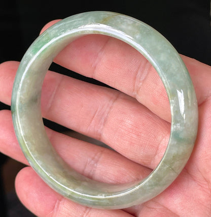 Close-up of fine crystalline texture and intricate natural jade veins on icy apple green jadeite bangle