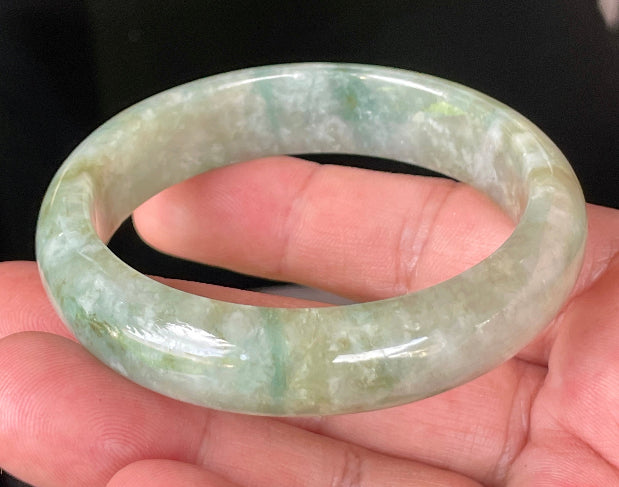 Close-up of fine crystalline texture and intricate natural jade veins on icy apple green jadeite bangle