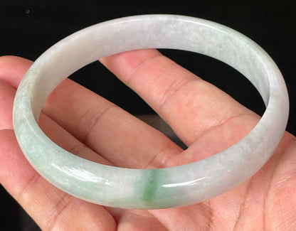 Close-up of fine crystalline texture and striking imperial green accent on icy greyish white jadeite bangle