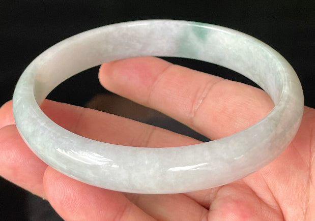 Close-up of fine crystalline texture and striking imperial green accent on icy greyish white jadeite bangle