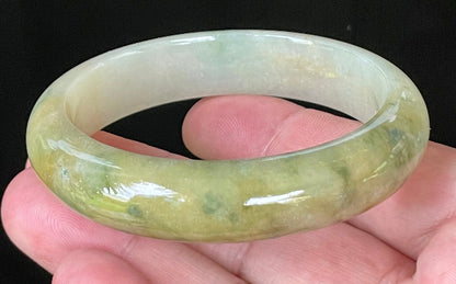 Close-up of fine crystalline texture and vivid green hues on icy yellow and white jadeite bangle