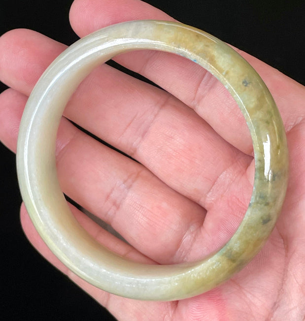 Close-up of fine crystalline texture and vivid green hues on icy yellow and white jadeite bangle