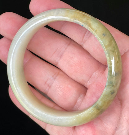 Close-up of fine crystalline texture and vivid green hues on icy yellow and white jadeite bangle