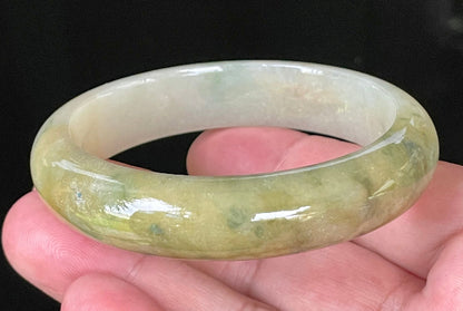 Close-up of fine crystalline texture and vivid green hues on icy yellow and white jadeite bangle
