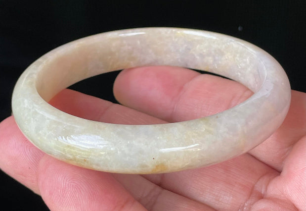 Close-up of fine crystalline texture and delicate light lavender hues on icy yellow and honey jadeite bangle