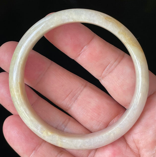 Close-up of fine crystalline texture and delicate light lavender hues on icy yellow and honey jadeite bangle