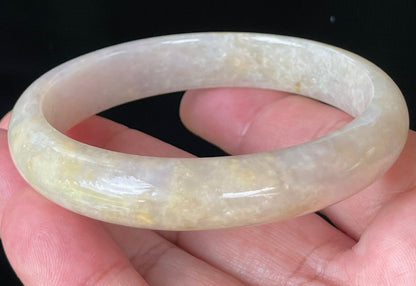 Close-up of fine crystalline texture and delicate light lavender hues on icy yellow and honey jadeite bangle