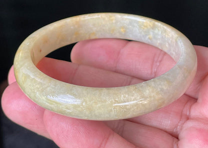 Close-up of fine crystalline texture and warm honey orange hues on icy yellow jadeite bangle