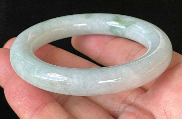 Close-up of fine crystalline texture and imperial green hues on icy milky white and grey jadeite bangle