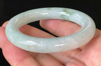 Close-up of fine crystalline texture and imperial green hues on icy milky white and grey jadeite bangle