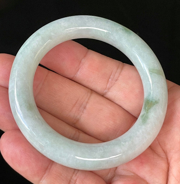 Close-up of fine crystalline texture and imperial green hues on icy milky white and grey jadeite bangle
