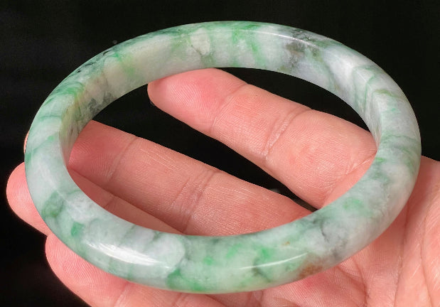 Close-up of fine crystalline texture and floral moss in the snow pattern on icy imperial green jadeite bangle