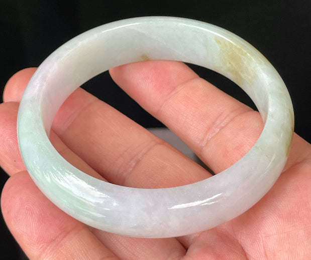 Close-up of fine crystalline texture and gentle lavender hues on icy milky white and green jadeite bangle