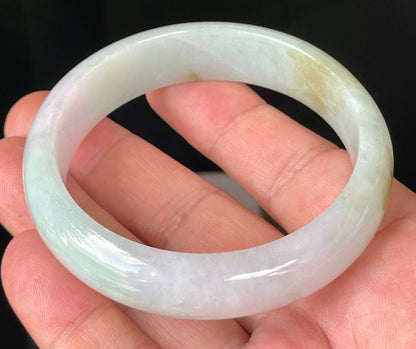 Close-up of fine crystalline texture and gentle lavender hues on icy milky white and green jadeite bangle
